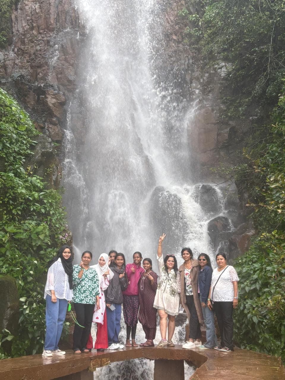 Soaked, cold and still smiling by the waterfall